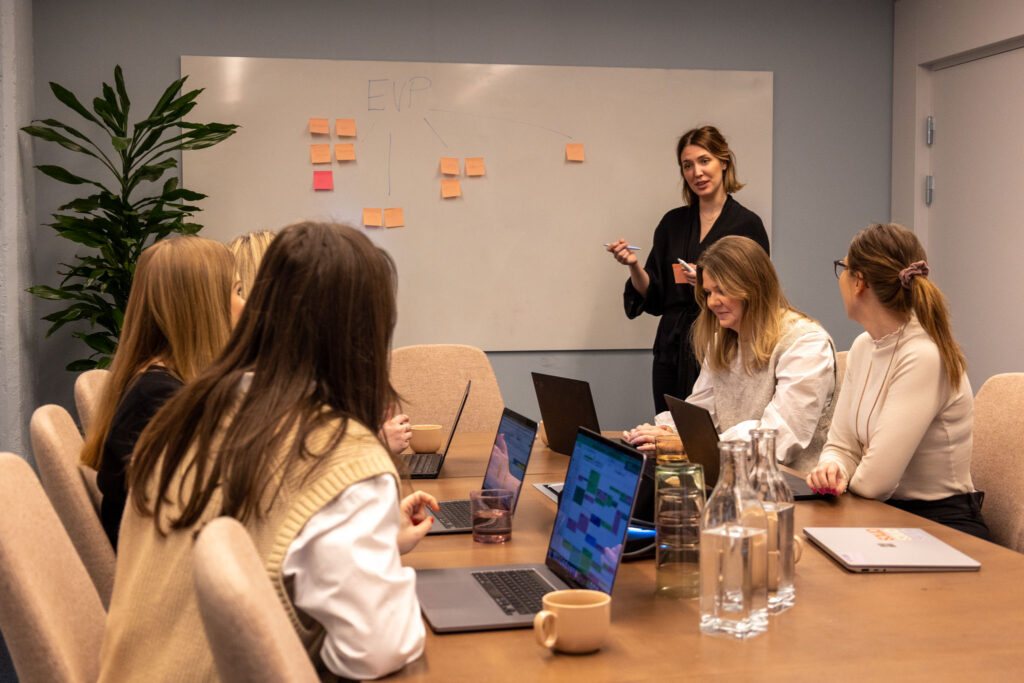 Personer på Ants HR Tech sitter i ett mötesrum och jobbar med leadership