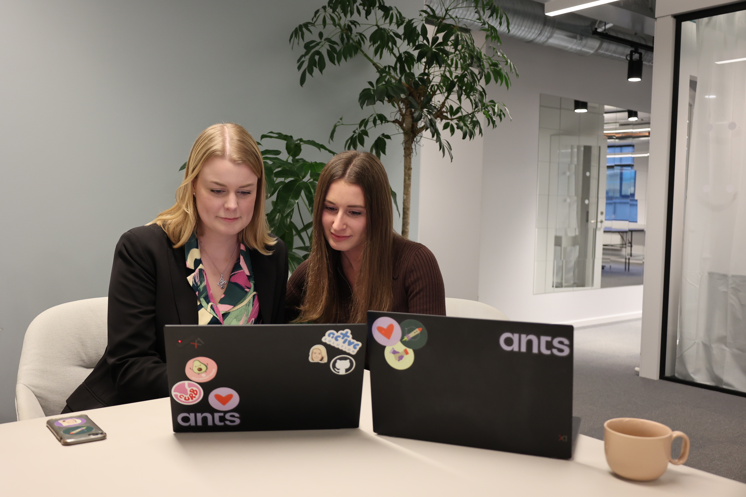 Två konsulter från Ants sitter och arbetar vid sina datorer och kan hjälpa till med Inbound Recruitment i Stockholm