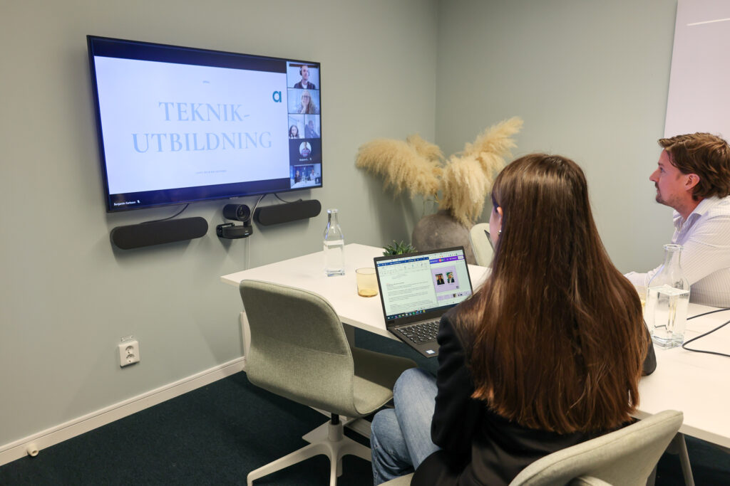 Två rekryterare från Ants sitter i ett digitalt möte i ett mötesrum och håller i en teknikutbildning.