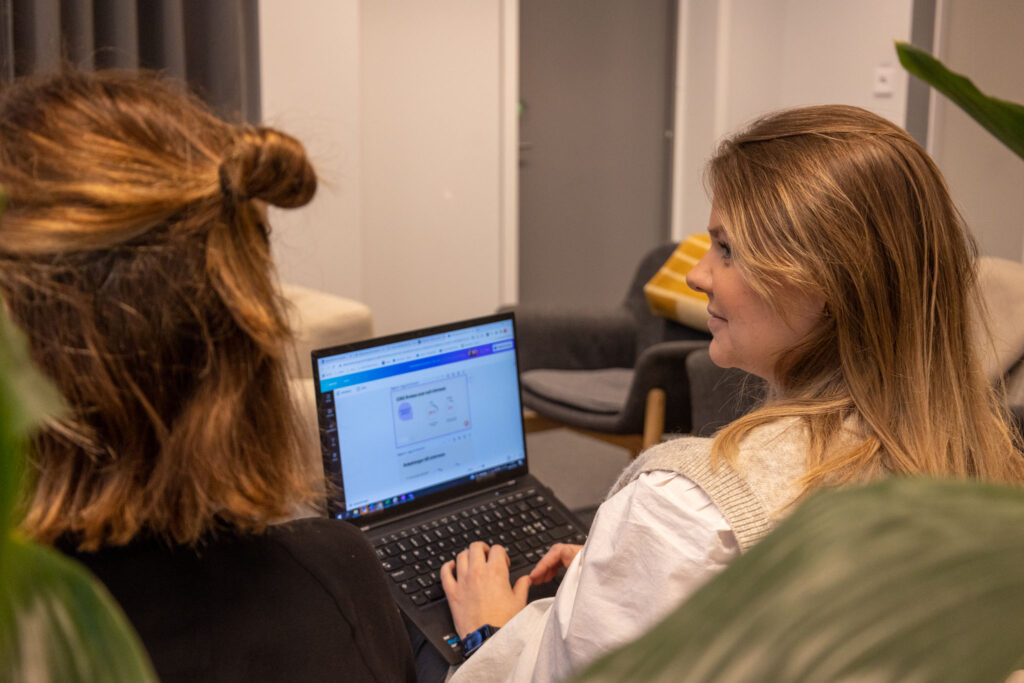 Två personer sitter i en soffa med laptop i knäet och pratar med någon utanför bild om datadriven rekrytering.