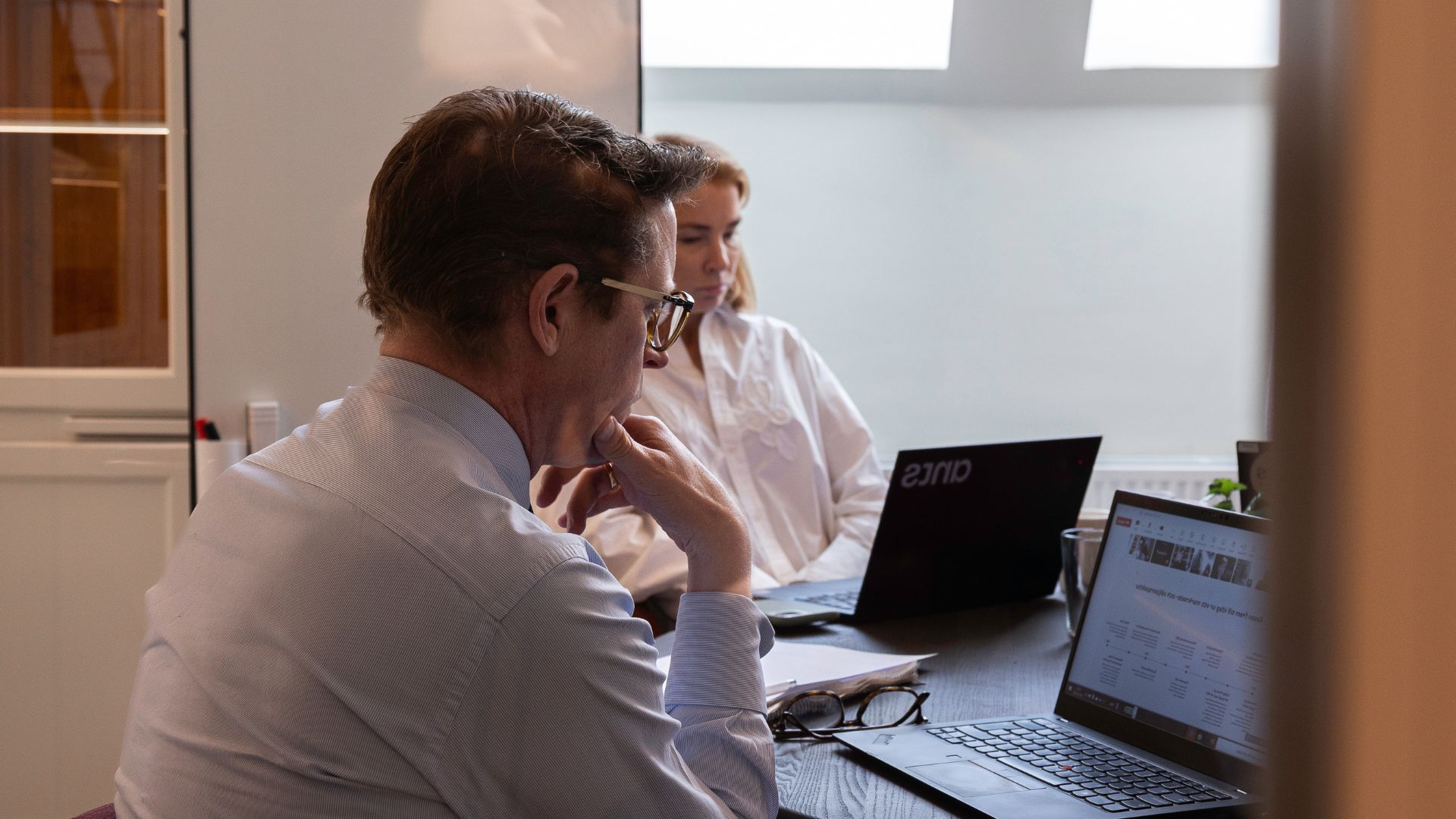 Två rekryterare som rekryterar ingenjörer och sitter med sina datorer i ett grupprum