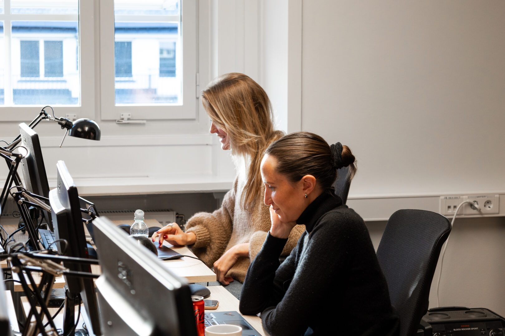 två IT-rekryterare som sitter vid sina datorer och arbetar med datadriven IT-rekrytering
