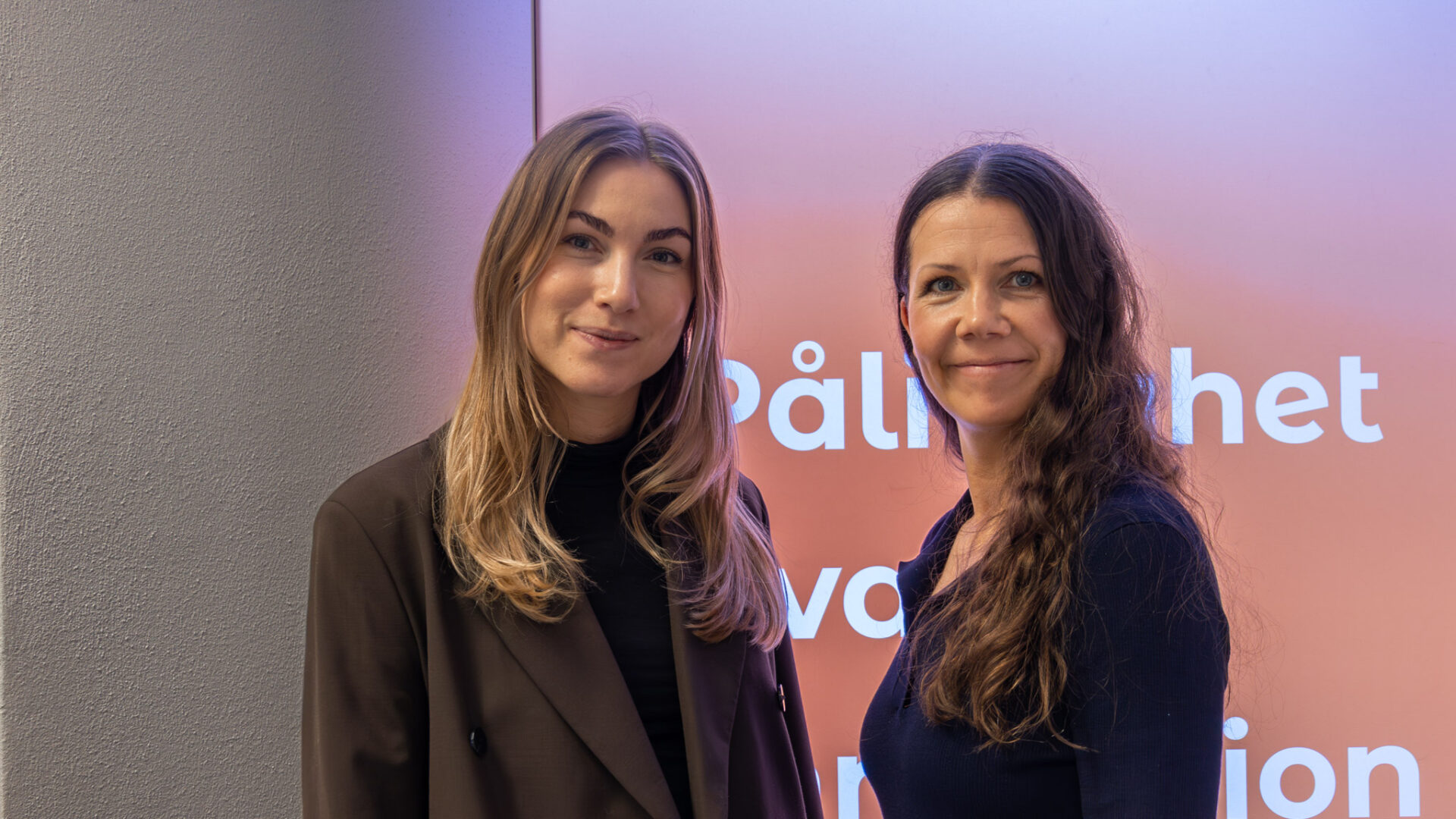 Två personer står och ler mot kameran